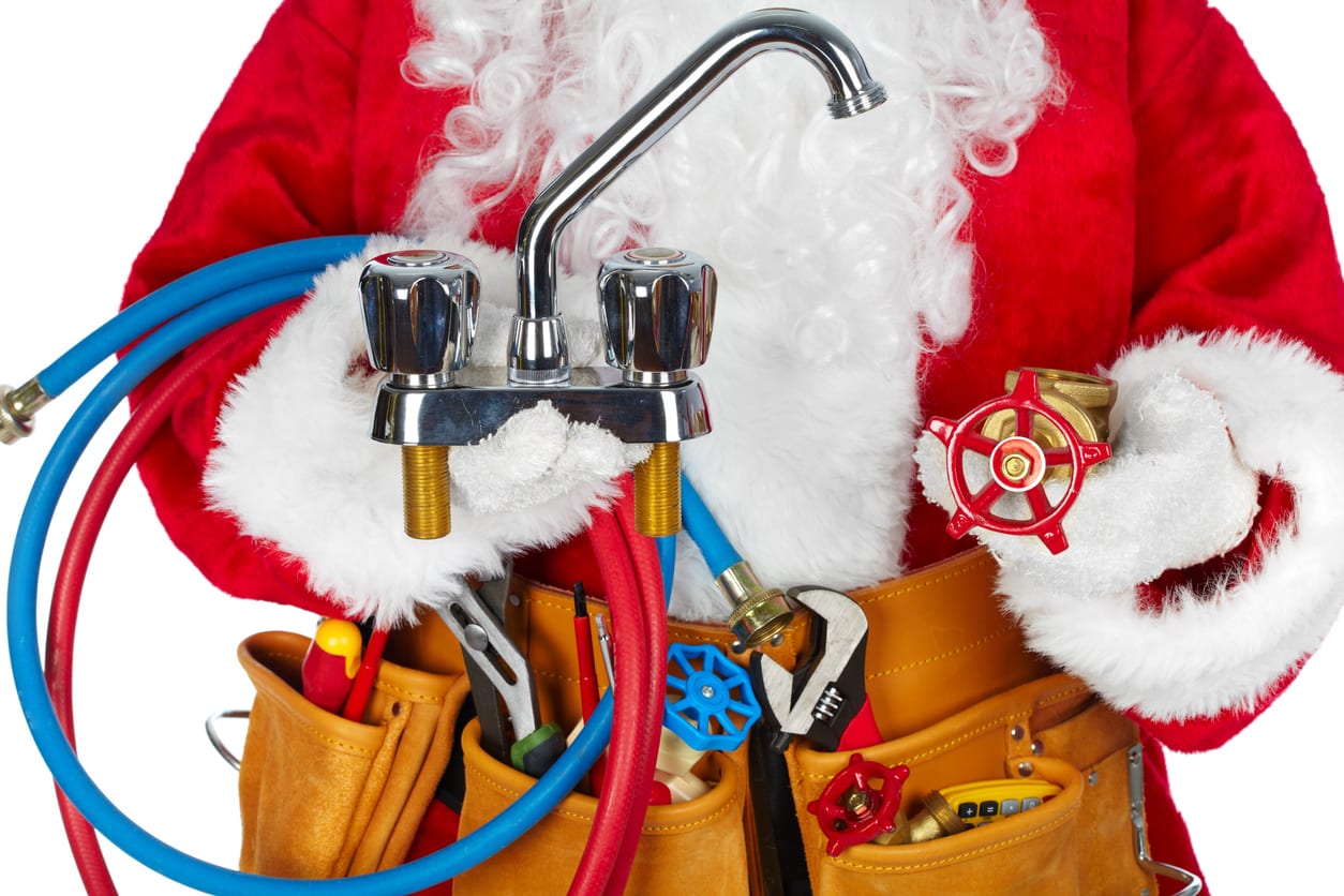 Person in a red Santa outfit holding plumbing tools, including a faucet, hoses, and wrench, with a tool belt full of additional equipment.