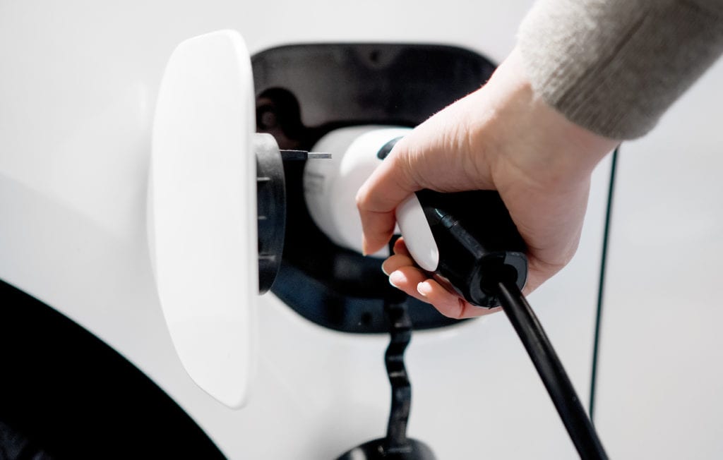 Hand holding electric plug for charging electric car.Hand holding electric plug for charging electric car.