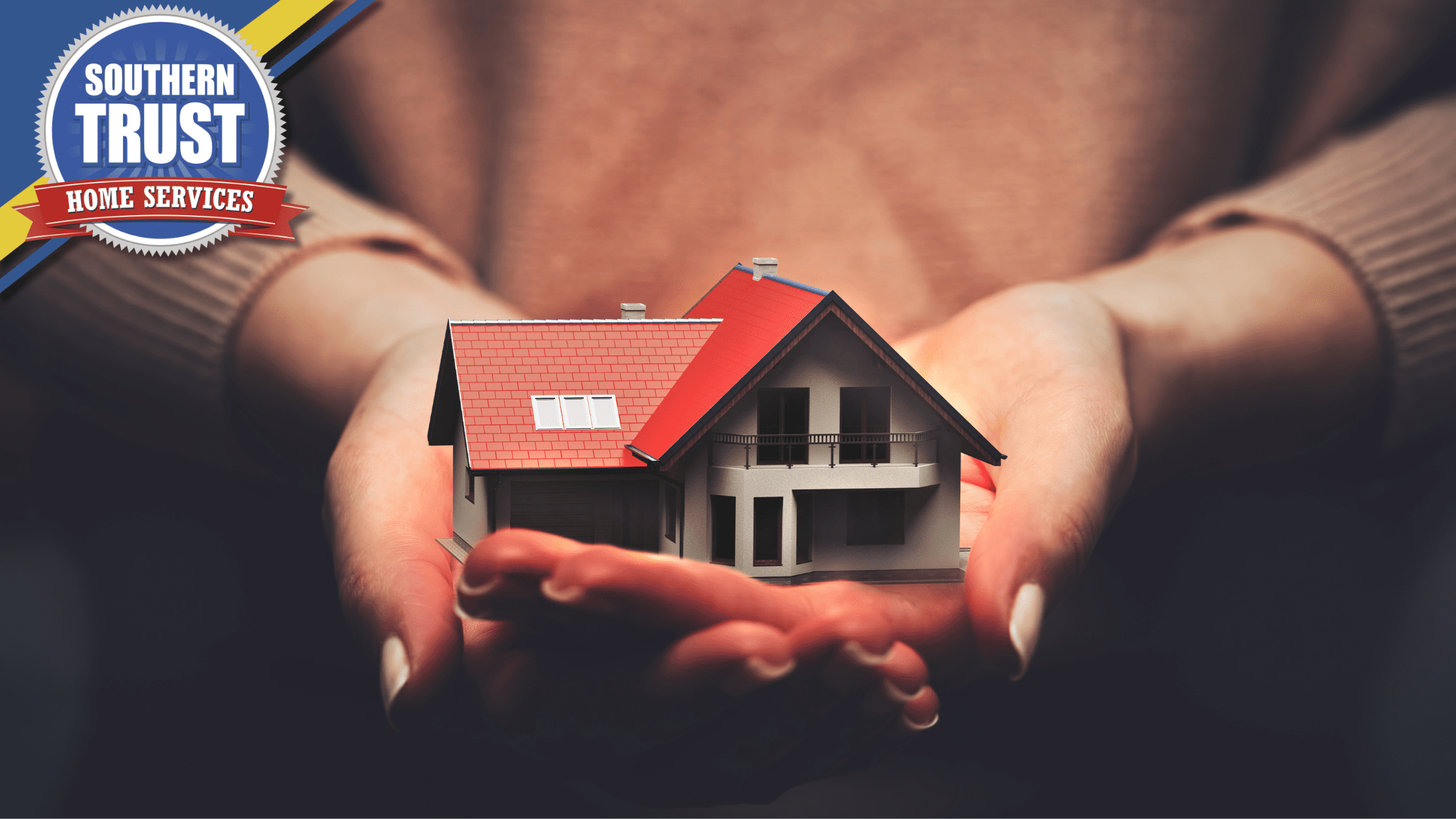 Hands holding a small model of a house with a red roof. A logo for Southern Trust Home Services is in the top left corner.